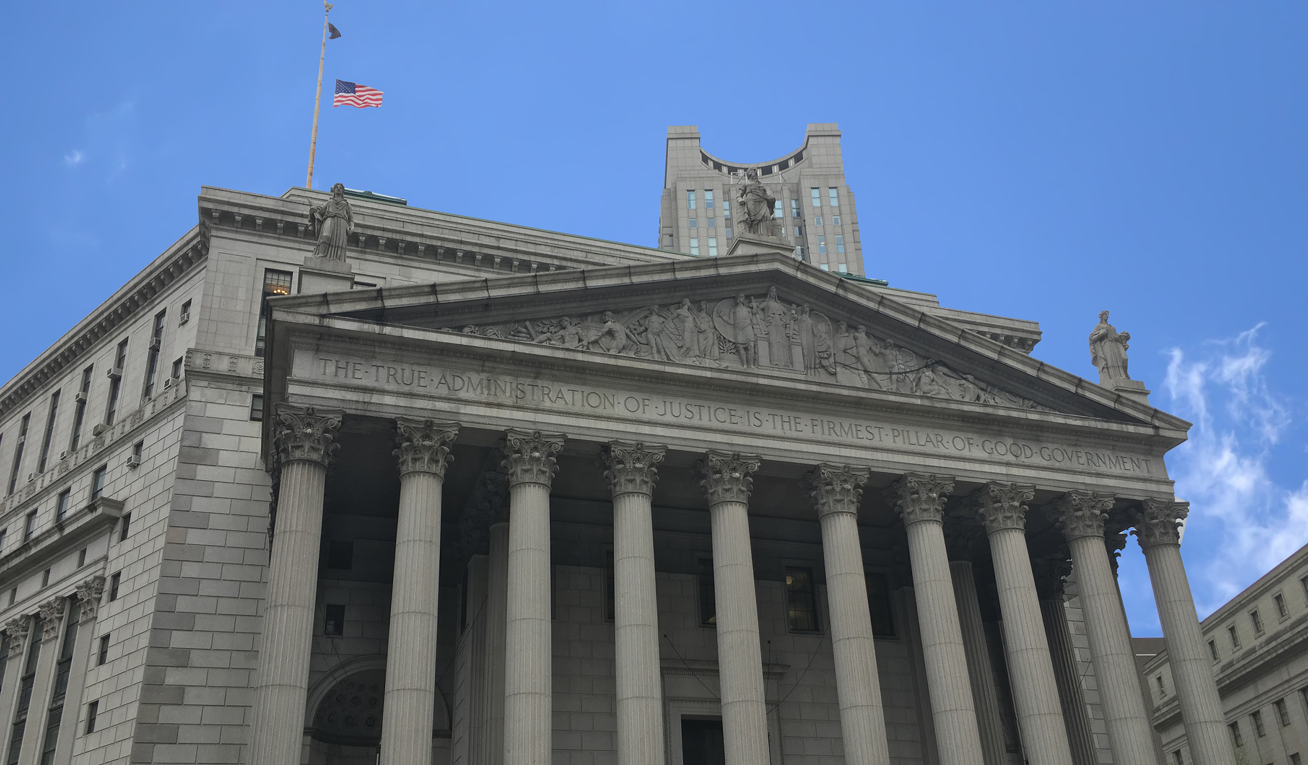 A courthouse with the words 'The true administration of justice is the firmest pillar of good government' across the facade.