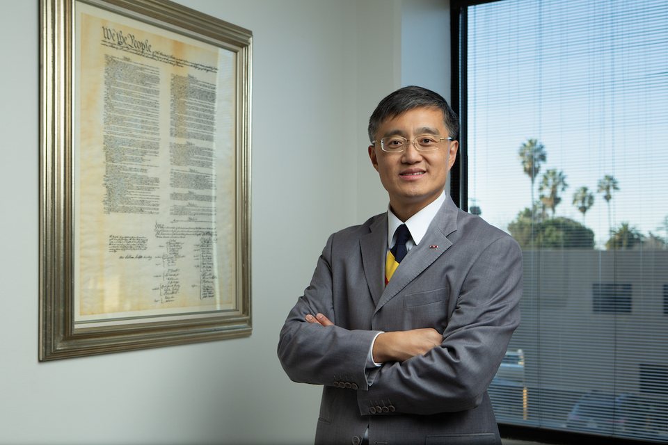 An IPLG attorney in the firm's office beside a framed copy of the U.S. Constitution